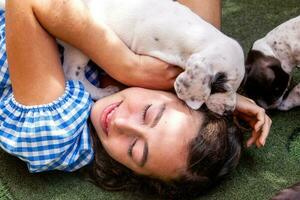 Beautiful young girl having fun with her small French Braque puppies photo