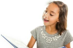 Lovely happy little girl reading a book isolated on white background photo