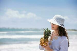 mujer teniendo un tropical bebida a un paradisíaco tropical playa en un hermosa soleado día foto