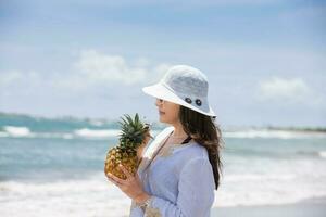 Woman having a tropical drink at a paradisiac tropical beach in a beautiful sunny day photo