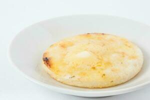 Traditional Colombian arepa topped with melted butter photo