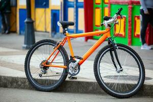 naranja bicicleta estacionado a el vistoso calles de de el pequeño pueblo de salento situado a el región de quindio en Colombia foto