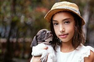 hermosa joven niña teniendo divertido con su pequeño francés braque perrito foto