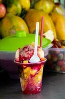 Preparation of a traditional sweet water ice with fruits called cholado in the city of Cali in Colombia photo