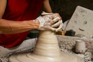 Man making ceramic articles on the potters wheel in a traditional factory in the city of Raquira located in the department of Cundinamarca in Colombia photo