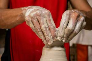 Man making ceramic articles on the potters wheel in a traditional factory in the city of Raquira located in the department of Cundinamarca in Colombia photo