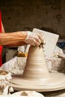 Man making ceramic articles on the potters wheel in a traditional factory in the city of Raquira located in the department of Cundinamarca in Colombia photo