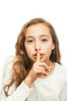 joven niña con participación dedo en su labios en silencio gesto aislado en blanco antecedentes foto
