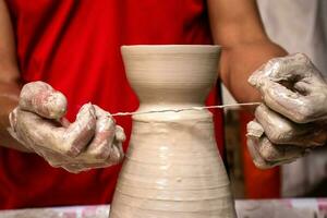 Man making ceramic articles on the potters wheel in a traditional factory in the city of Raquira located in the department of Cundinamarca in Colombia photo