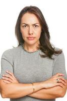 Upset unsatisfied woman standing with arms folded and looking at camera isolated over white background photo