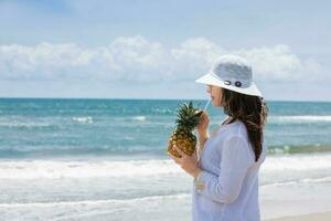 Woman having a tropical drink at a paradisiac tropical beach in a beautiful sunny day photo