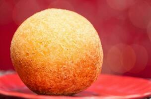 Traditional Colombian bunuelos. Deep Fried Cheese Bread on christmas red background photo