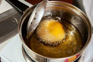 Preparation of the traditional dish from the Caribbean Coast in colombia called Arepa de Huevo or egg arepa photo