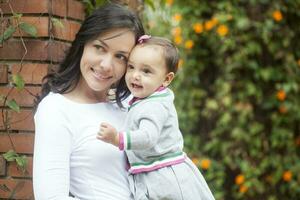 mamá y bebé niña a el jardín foto