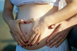 Couple at the beach waiting for their baby - 28 weeks photo