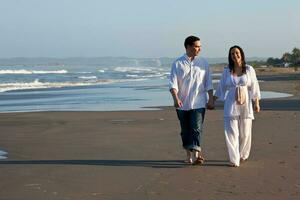 Couple at the beach waiting for their baby - 28 weeks photo