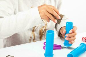 joven niña haciendo un juguete microscopio con reciclable material foto