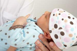 Close up of a father hands holding his one month baby girl isolated on white background photo