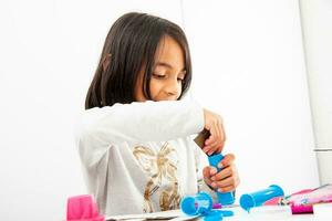 Young girl making a toy microscope with recyclable material photo