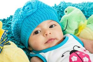 cuatro meses antiguo bebé vistiendo un azul gorra y traje de baño foto