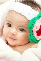 Sweet four months baby girl wearing a crocheted headband photo