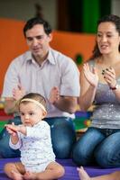 Young parents playing with their nine months baby girl. Happiness concept. Learning and education concept photo