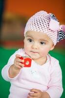 Portrait of a beautiful nine months baby playing on a colorful background. Learning concept photo