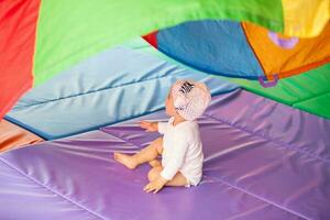 Portrait of a beautiful nine months baby playing on a colorful background. Learning concept photo