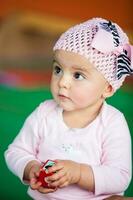 Portrait of a beautiful nine months baby playing on a colorful background. Learning concept photo