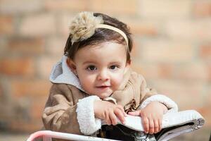 Sweet one year old baby girl playing outdoors. photo