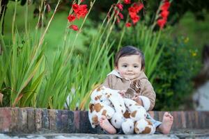 dulce uno año antiguo bebé niña jugando al aire libre. foto