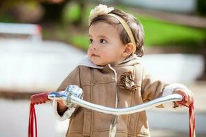 Sweet one year old baby girl playing outdoors. photo