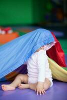 Portrait of a beautiful nine months baby playing on a colorful background. Learning concept photo