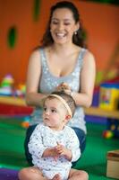 Portrait of a beautiful nine months baby playing with her mom. photo