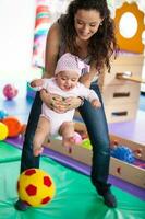 Portrait of a beautiful nine months baby playing with her mom. photo