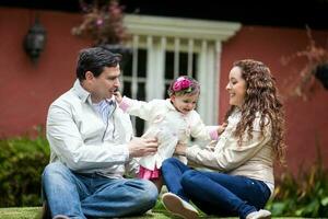 Young parents having fun outdoors with their one year old baby girl. Happiness concept. Family concept photo