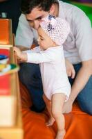 Portrait of a beautiful nine months baby playing with her dad. photo