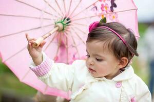 Sweet one year old baby girl playing outdoors. photo