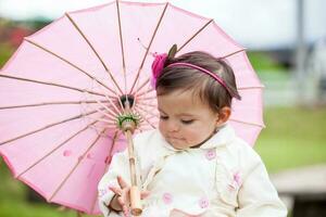 Sweet one year old baby girl playing outdoors. photo