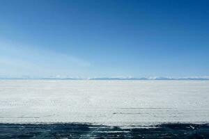 Baikal mountains in winter in snow. Forest in snow covered mount photo