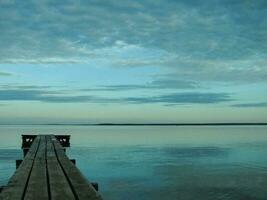 un largo de madera muelle en el costas de lago naroch foto