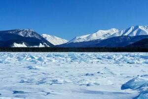 shore of Lake Baikal in winter. Snow and ice on the baikal. photo