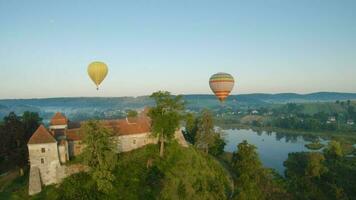 vistoso caliente aire globos mosca terminado el medieval castillo y lago en el Mañana niebla. maniobrable vuelo. viajar, aventura, festival. video