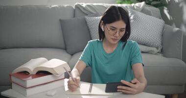 Cute girl learning online on smartphone in living room photo