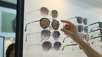 Closeup of hand holding eyeglasses in optical shop, hand holding glasses video