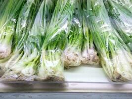 green onion with  plastic bag on display In the mall , fresh Onion photo