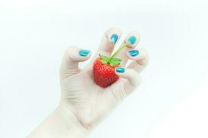 Fresco fresas en mano, un apetitoso fresa en el mujer burlas mano a el blanco antecedentes foto