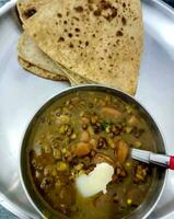 A bowl with Rajma and a plate of parantha photo