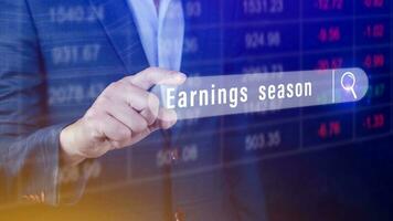 Earnings season Hand touching of written in search bar with the financial data visible in the background,  Reports Stock Market Ticker Words photo