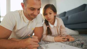 padre y hija son teniendo divertido y pintura juntos. concepto de un contento familia y calidad ocio hora video